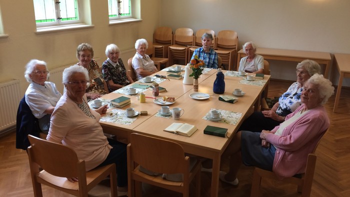 Seniorengruppe beim Essen in einem hellen Raum