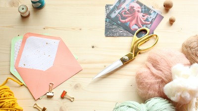 Bastelmaterialien wie Wolle, Schere, Karten und Bänder auf einem Tisch