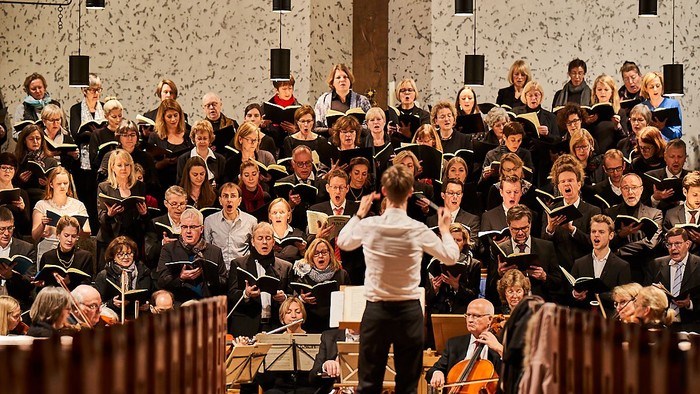 Ein großer Chor proben unter Leitung eines Dirigenten