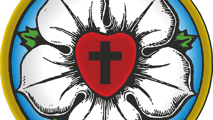 Das Bild zeigt eine weiße Lilie mit einem roten Herzen und einem schwarzen Kreuz in der Mitte.