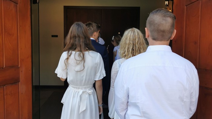 En gruppe af mennesker står i en hal, der ser ud over en trappe.