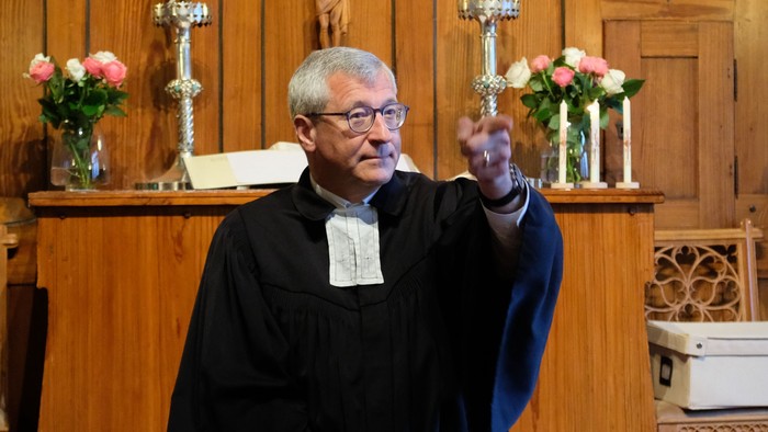 Ein Priester steht vor einem Altar in einer Kirche.