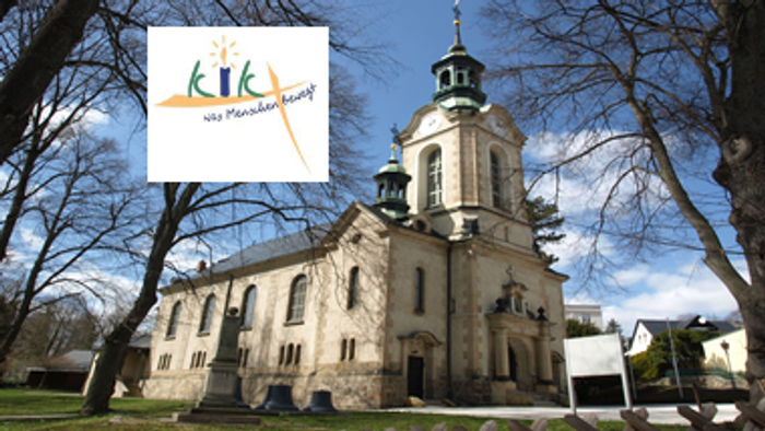 Das Bild zeigt eine Kirche mit einem Turm und einem Logo mit der Aufschrift "KIK".