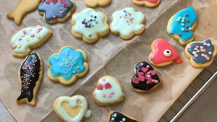 Bunte Kekse in verschiedenen Formen und Farben auf Backblech