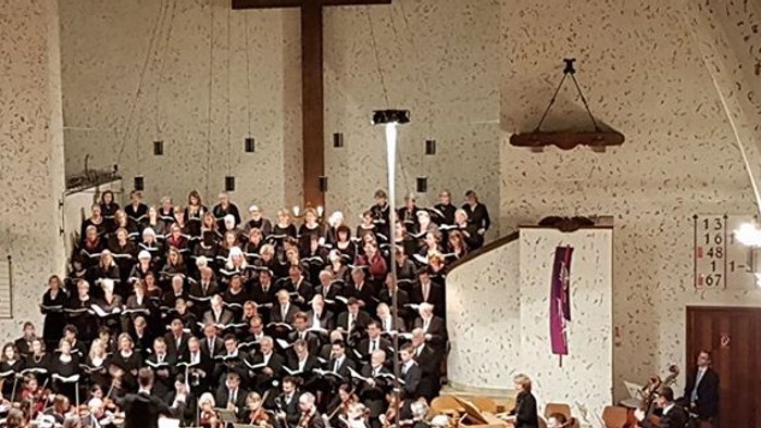 Große Kirchenchor singt unter Kreuz und Kronleuchtern
