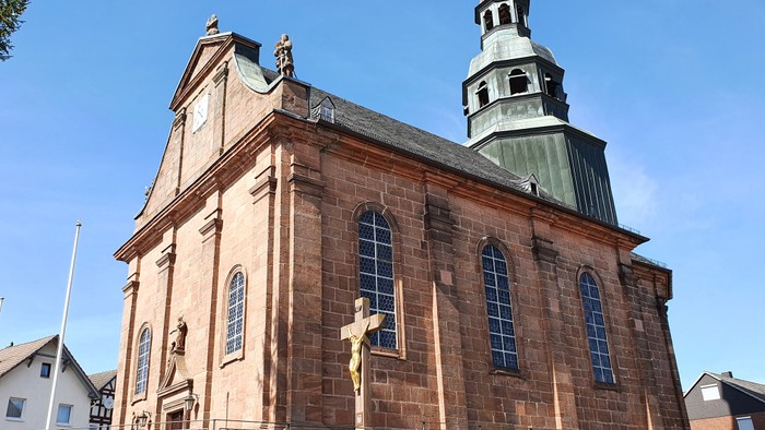 Große Kirche mit hohem Turm und Kreuz im Vordergrund