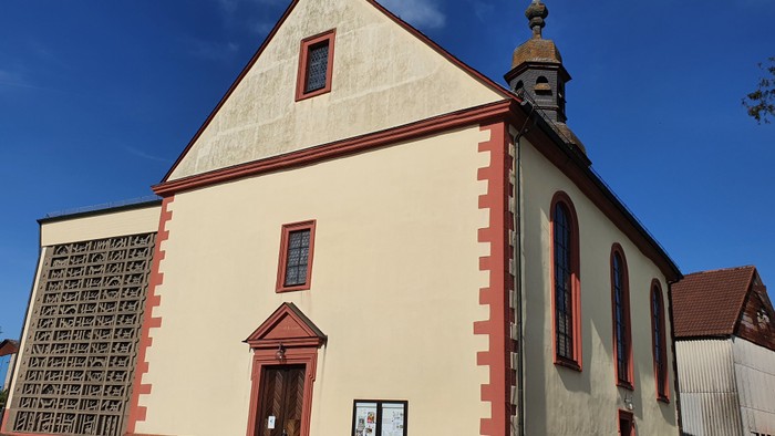 Kleine Kirche mit rotem Zierband und kleiner Kuppel.