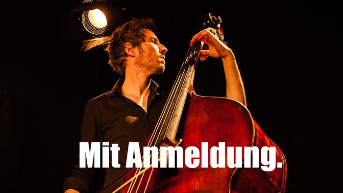 Ein Mann spielt auf einer Bühne mit einem Cello.
