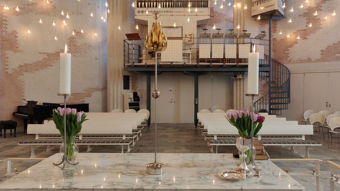 En stor festlokale med hvidt indretning og lysstråler.