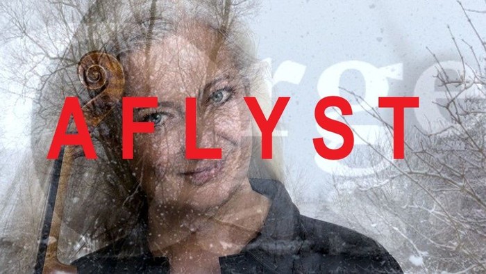 En kvinde spiller violin i snefaldende landskab