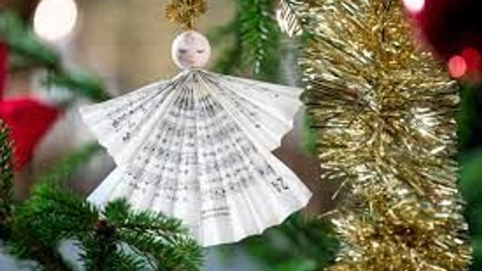 En hvid juledekoration i form af en danser med gyldne trægren.