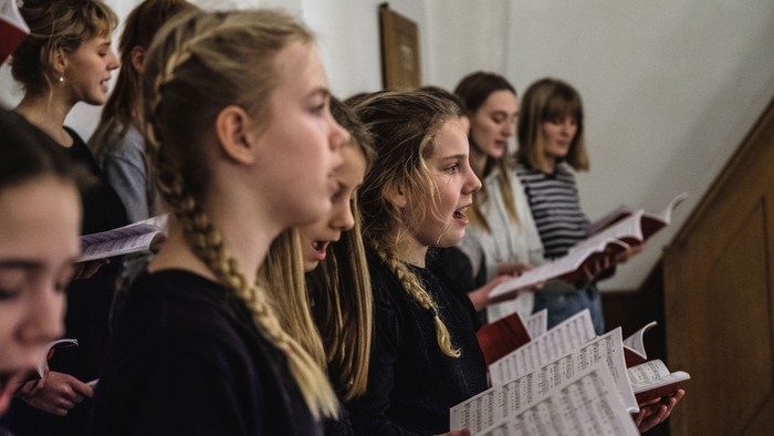 En gruppe unge piger synger i kor.