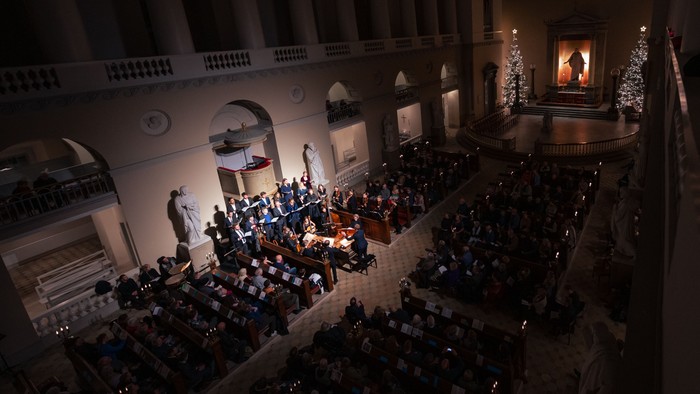 En stor koncertsal med publikum og orkester på scene