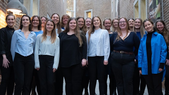 Gruppe af kvinder, der poser sammen udenfor en bygning