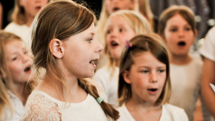 En gruppe unge piger synger i kor.