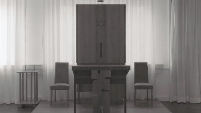 Ein modernes Wohnzimmer mit einem großen Kamin und zwei Stühlen.