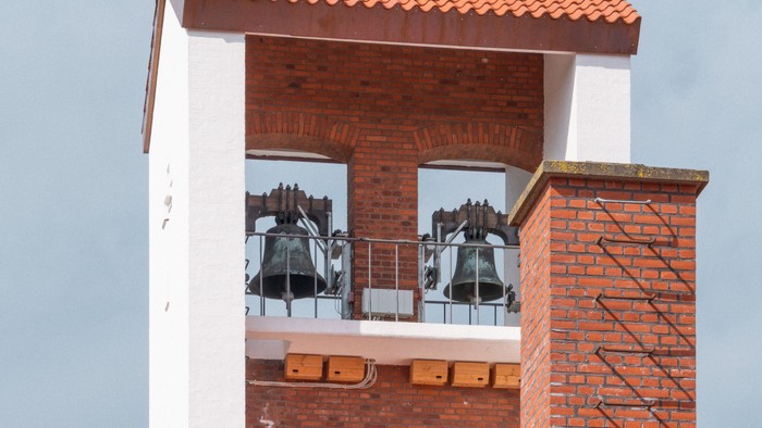 Tårn med røde teglsten og klokker.