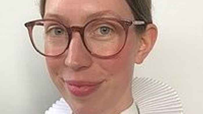 En kvinde med briller og hvid krage.