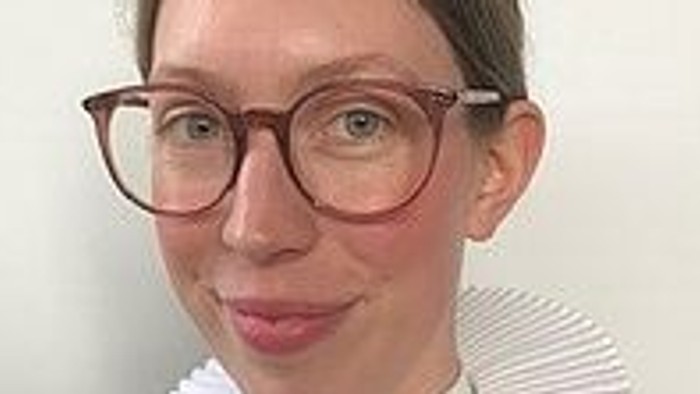 En kvinde med briller og hvid krage.