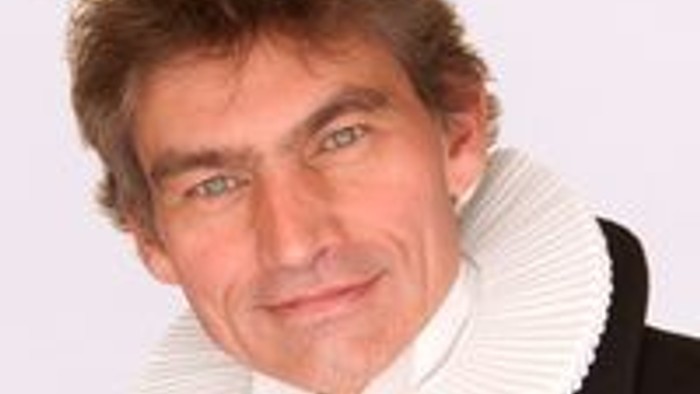 En mand med hvid krage og sort kappe.