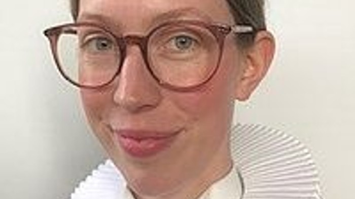 En kvinde med briller og hvid krage.