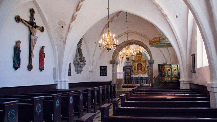 Indre del af kirke med alter og bænke.