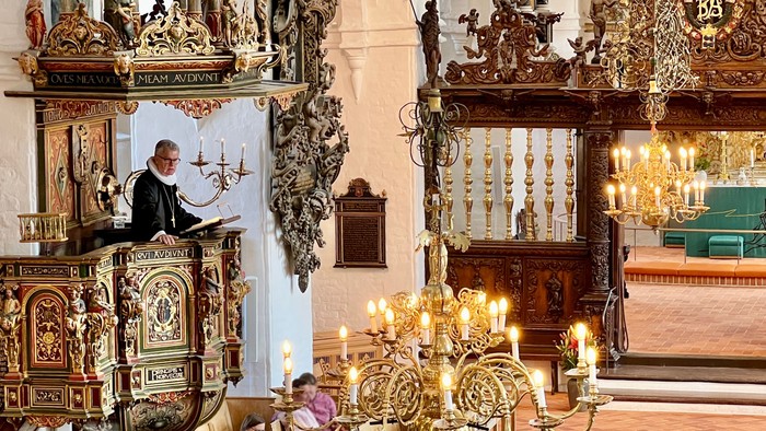 Indenrigs i en prægtig kirke med gulddekor og høje kældere.