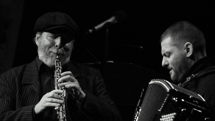 To oldere mænd spiller musik på klarinet og akkordeon