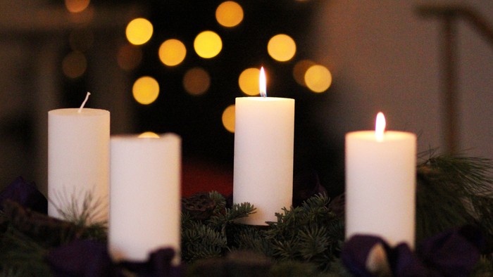 Firelyse på adventskranse foran juletree