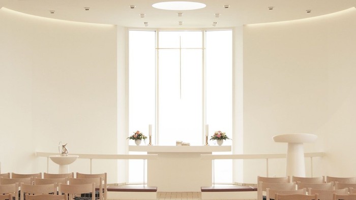 Rundt og lys rum med lang, smuk table og mange stoler