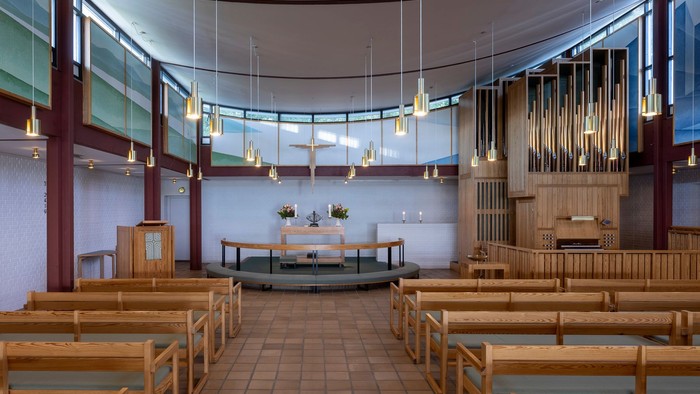 Indre del af kirke med træbænke og lysstak