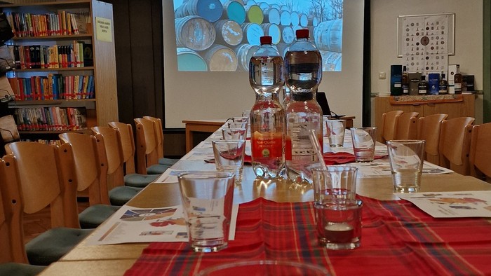 Ein Konferenzraum mit Tisch, Gläsern und Projektionsbildschirm