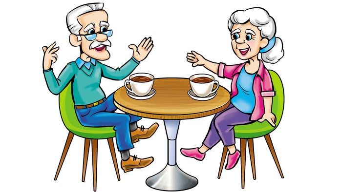 Ein älteres Paar sitzt an einem Tisch und trinkt Kaffee.