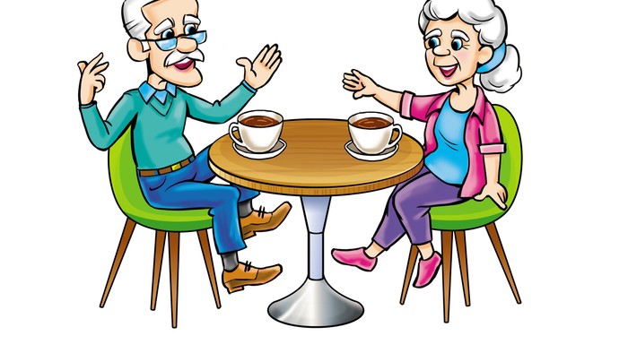 Ein älteres Paar sitzt an einem Tisch und trinkt Kaffee.