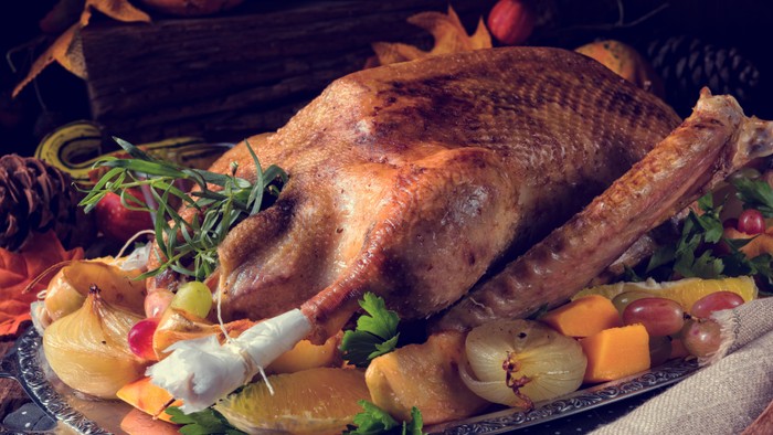 En stykket kylling med roser og citroner på en servieret.