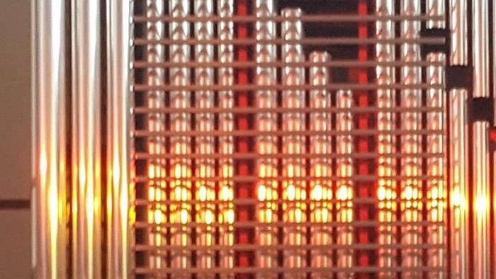 Metallische Rohre vor rotem Hintergrund