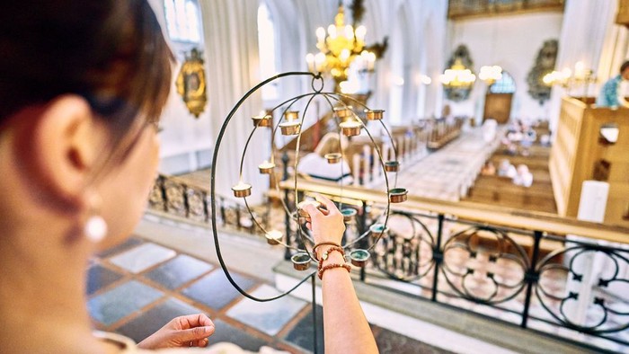 En kvinde i kirke med spejl og lysstake