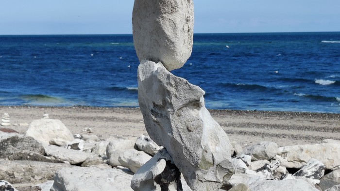 En stenbalancerer på stranden ved havet