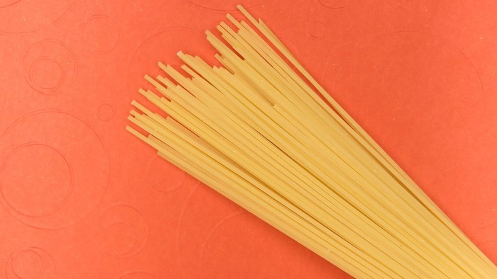 Gul spaghetti på rød underlag