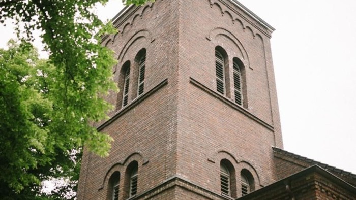 Der Kirchturm aus Ziegeln ragt hoch in den Himmel