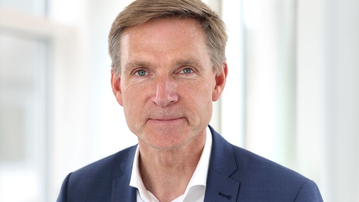 En middlealder mand med kort hår og blå suite.