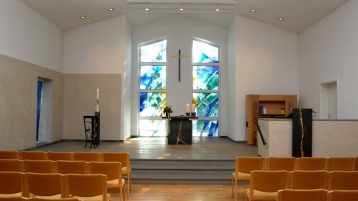 Modern Kirche mit großen bunten Fenstern und Holzbänken