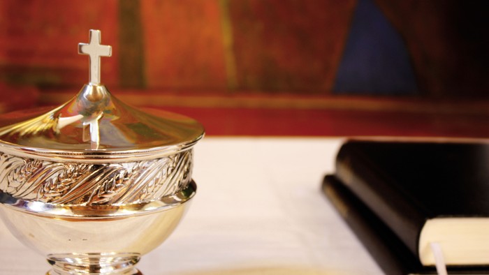 En sølv kalix med kors på dækkelen på alteret