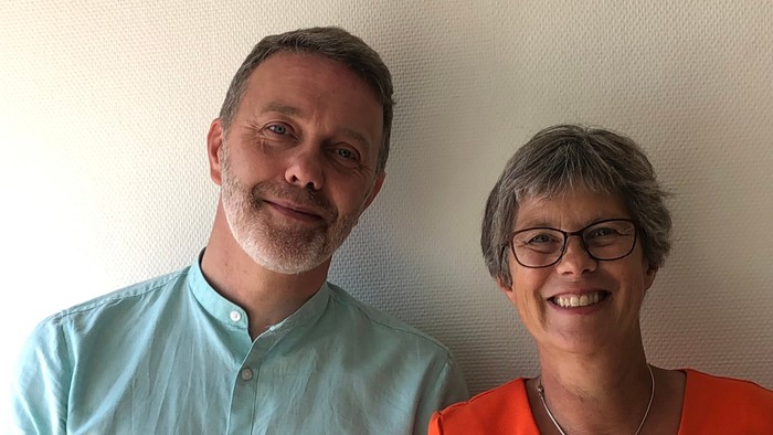 En mand og en kvinde står sammen og smiler til kameraet.