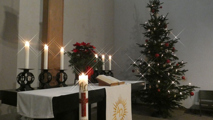 Weihnachtsdekoration in Kirche mit Kerzen und Christbaum