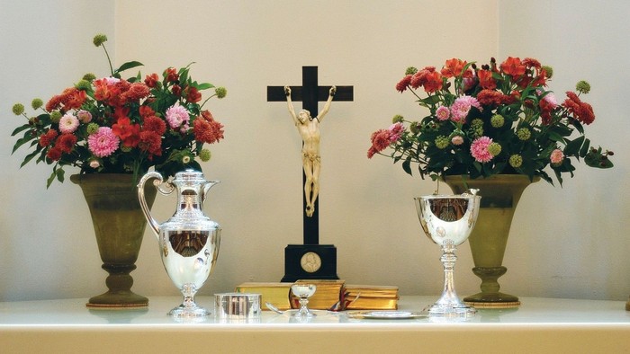 Altaret er dekket med blomsterarrangementer og religiøse symboler