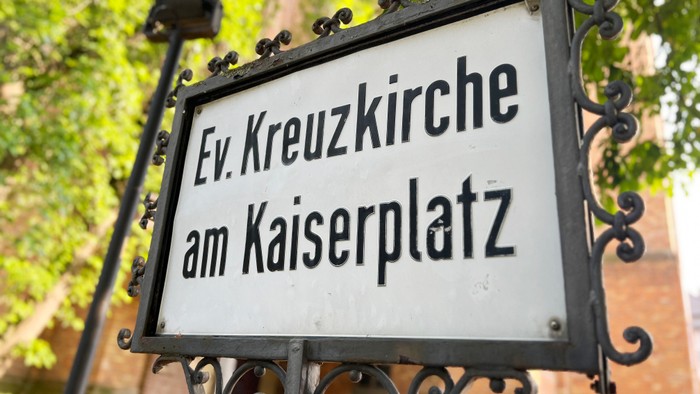Das Schild zeigt "Ev. Kreuzkirche am Kaiserplatz".