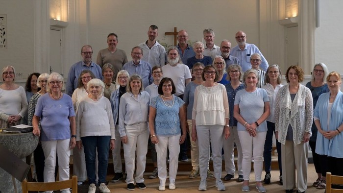 En gruppe af sygeplejersker og ansatte i sygehusstand, stående sammen i en gruppebillede.