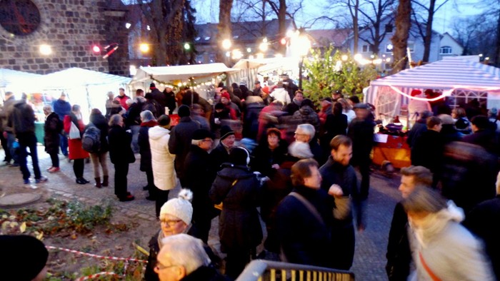 Menschenmenge auf belebten Weihnachtsmarkt bei Nacht