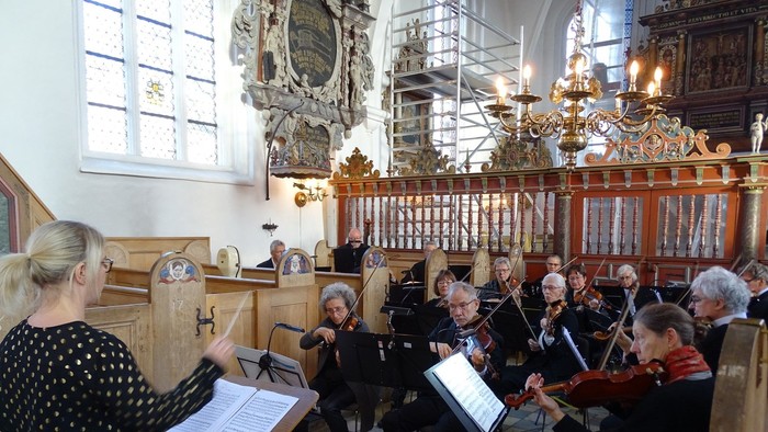 En koncert i kirke med orkester og dirigent